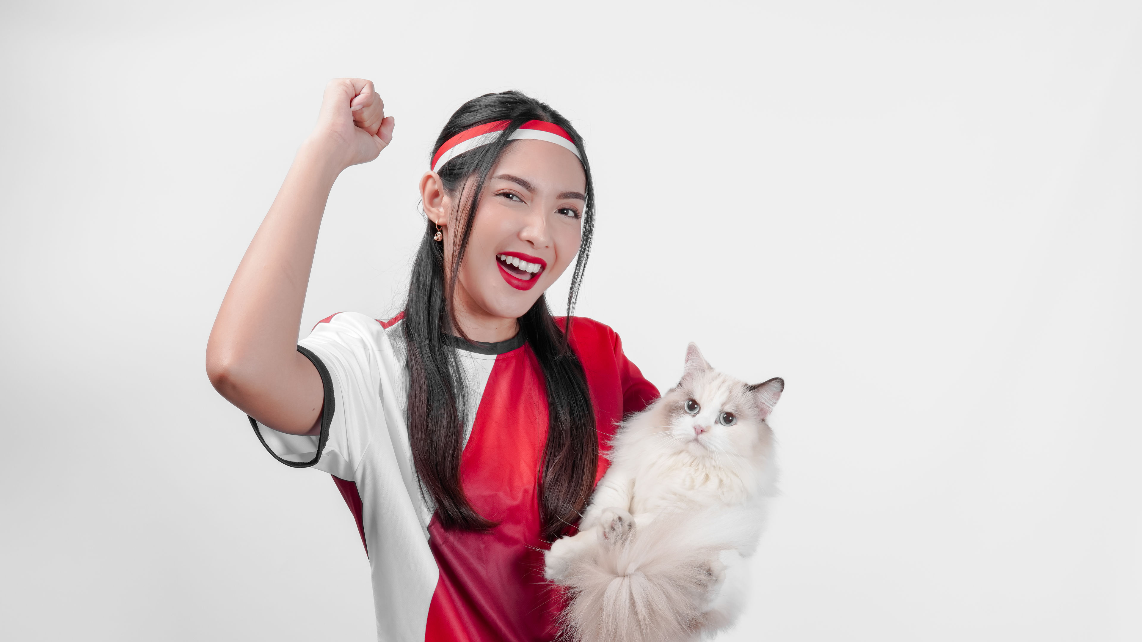Isang masayang dalaga na nakasuot ng pula at puting sports jersey