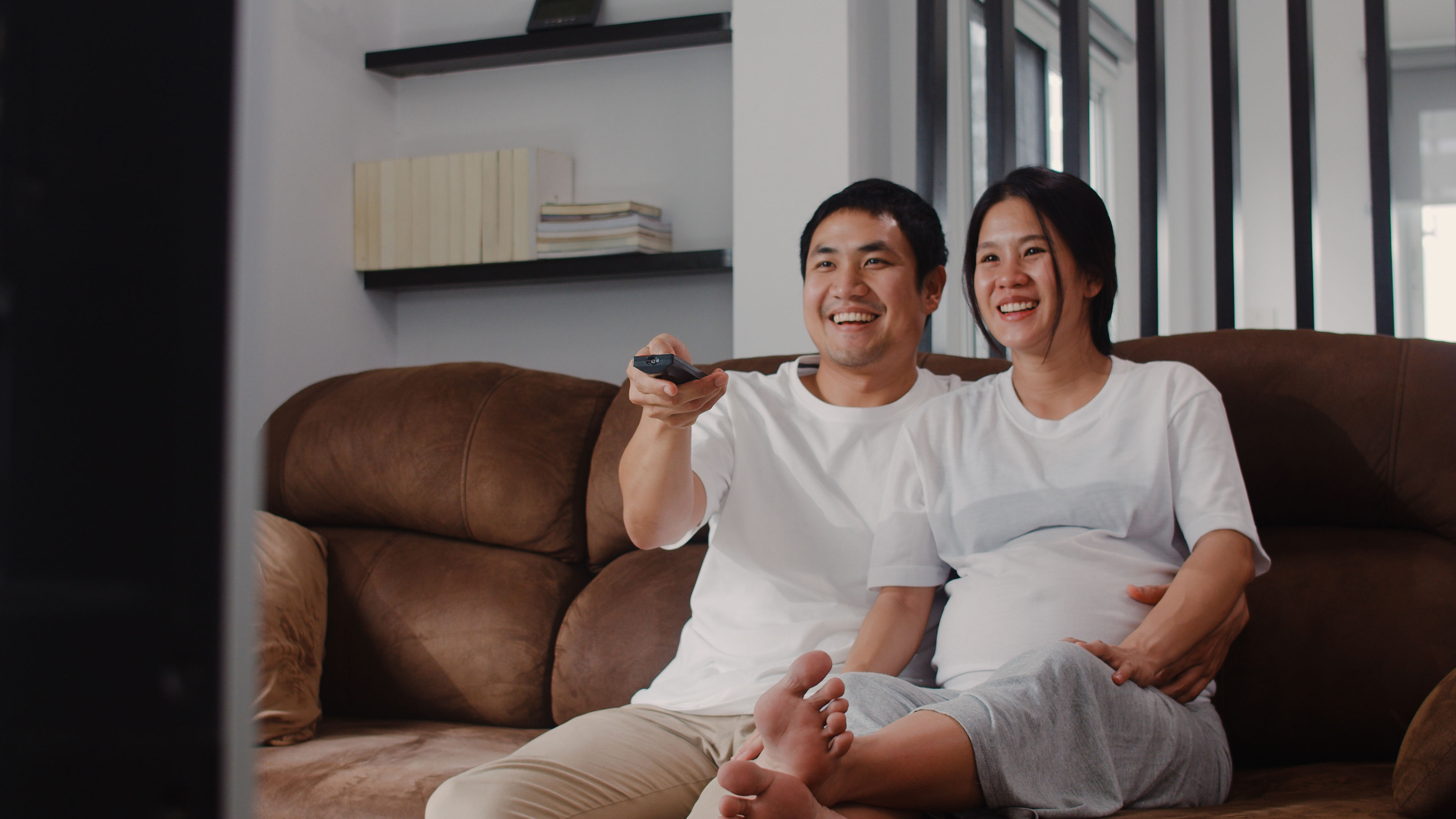 A couple holding a remote in hand 