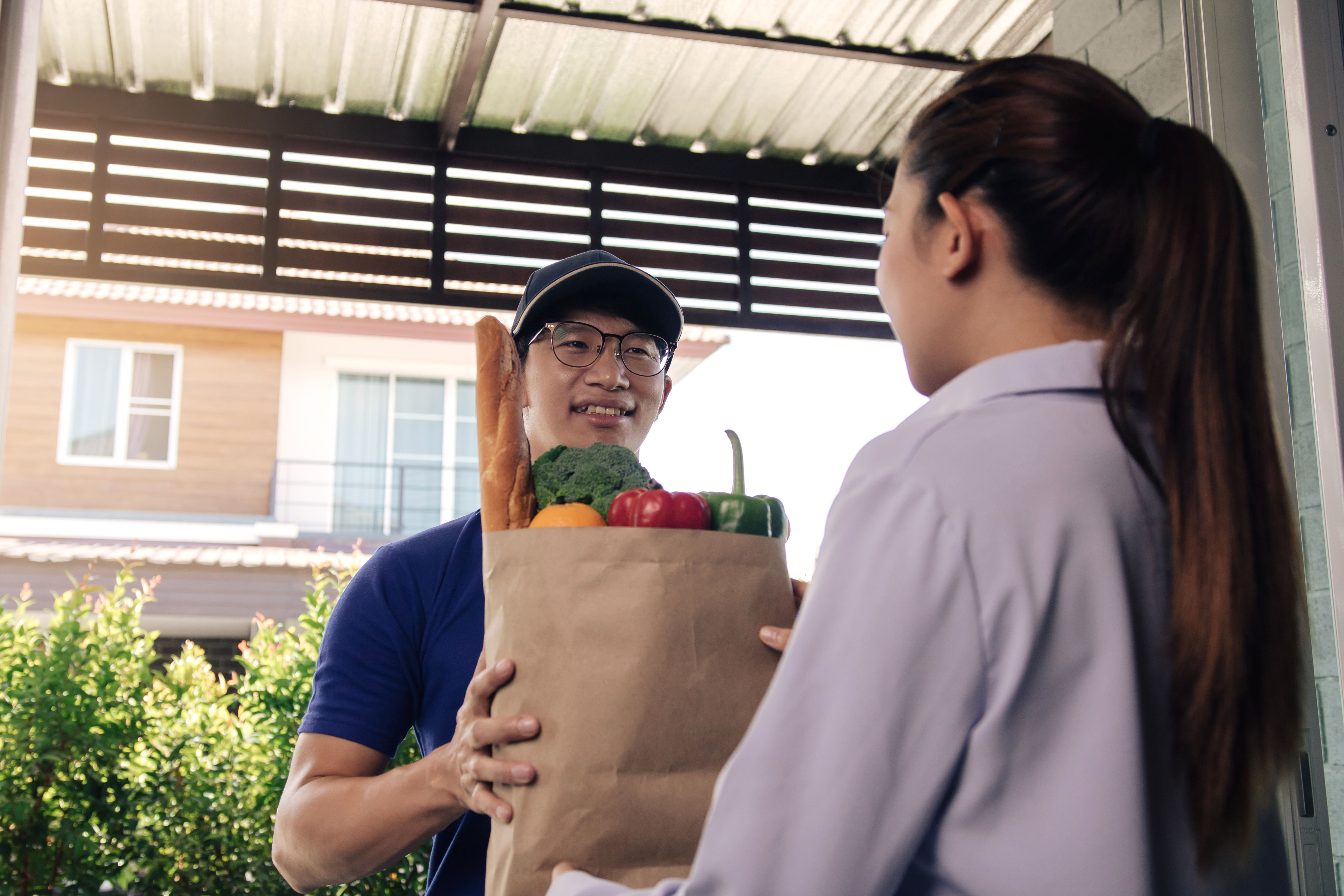 A delivery man delivers groceries. 