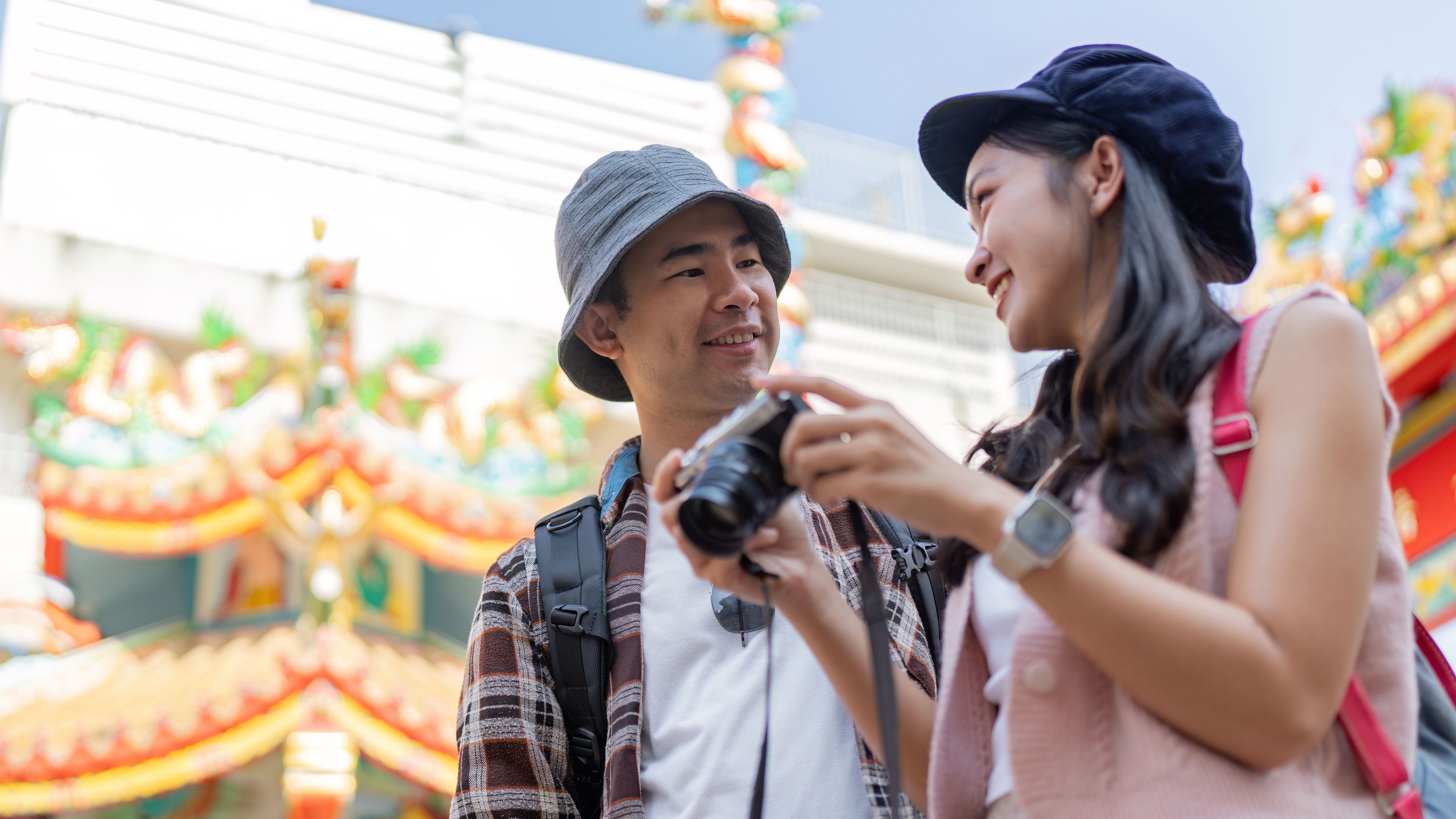 A joyful couple captures memories while a vibrant cultural landmark