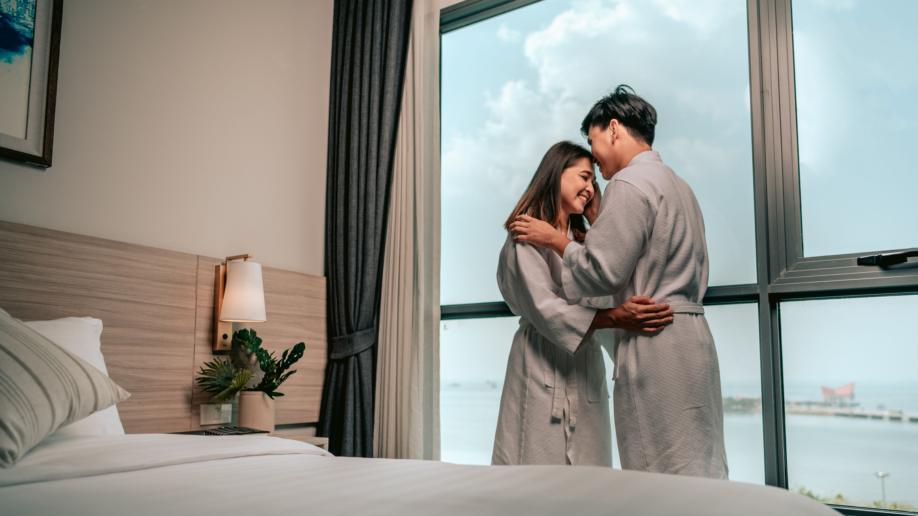 Asian Couple Kissing in Hotel