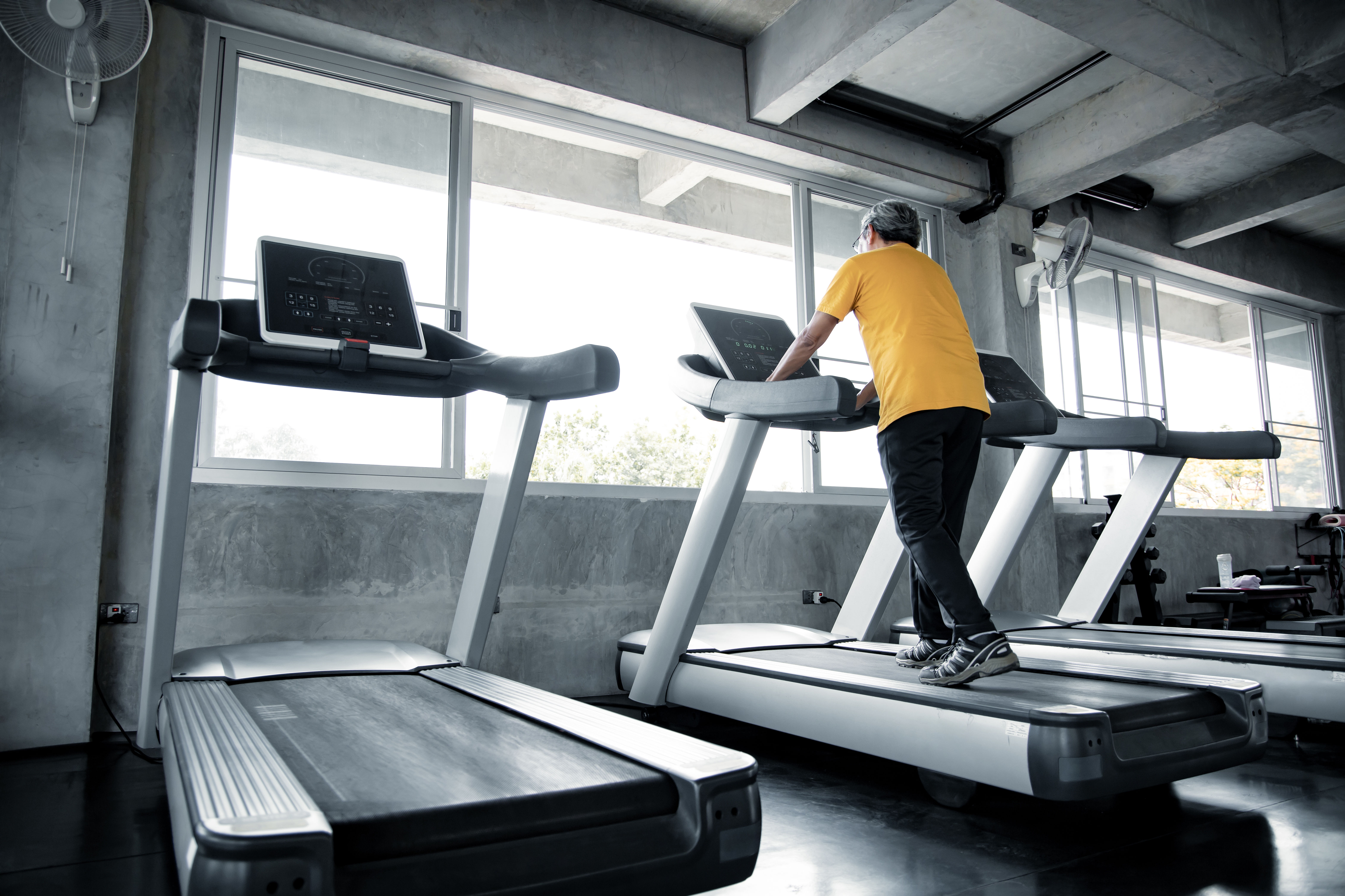 Ang mga matatandang lalaki ay nag eehersisyo sa running machine sa gym 