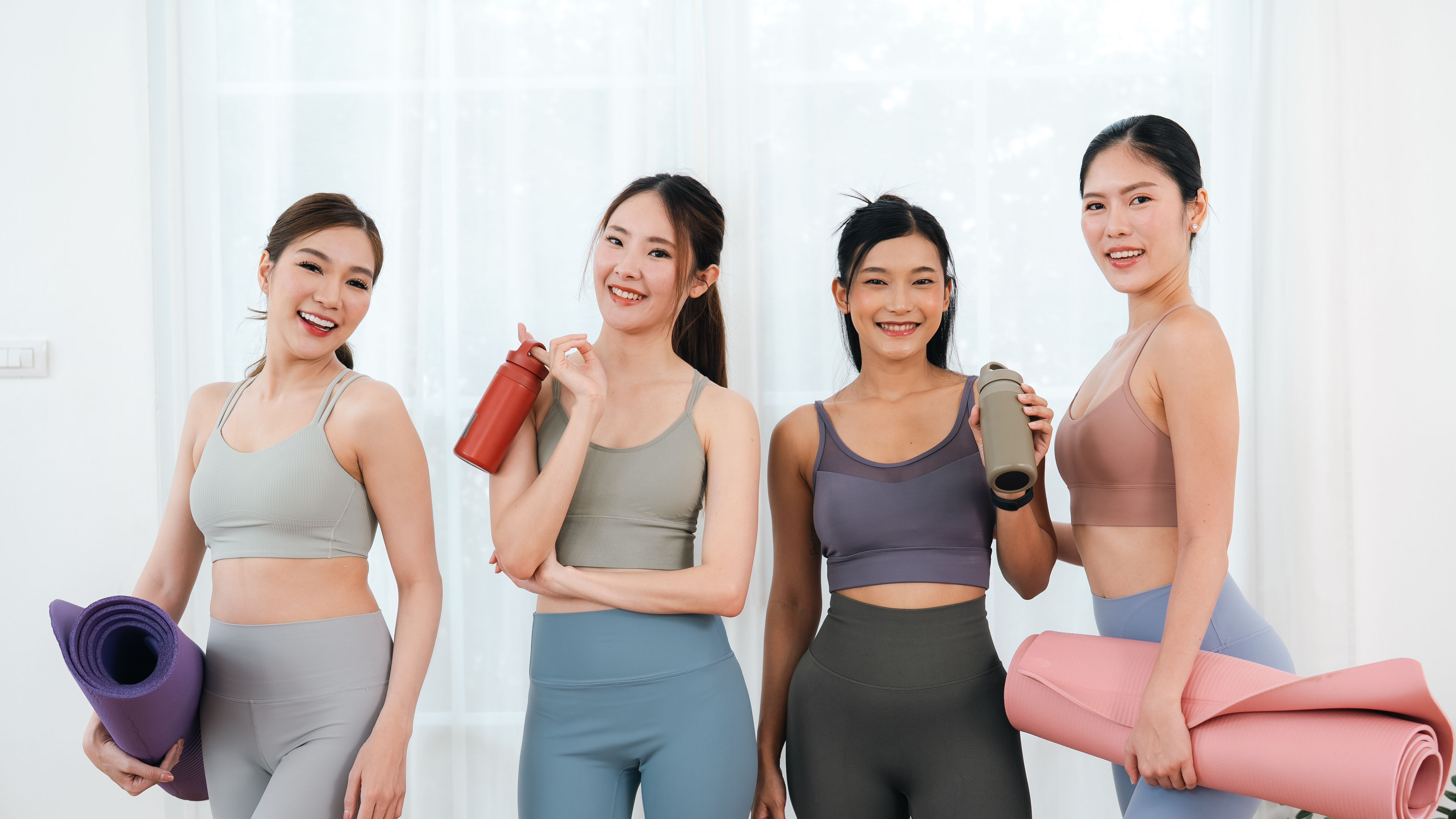 Four Smiling Women Holding Yoga Mats