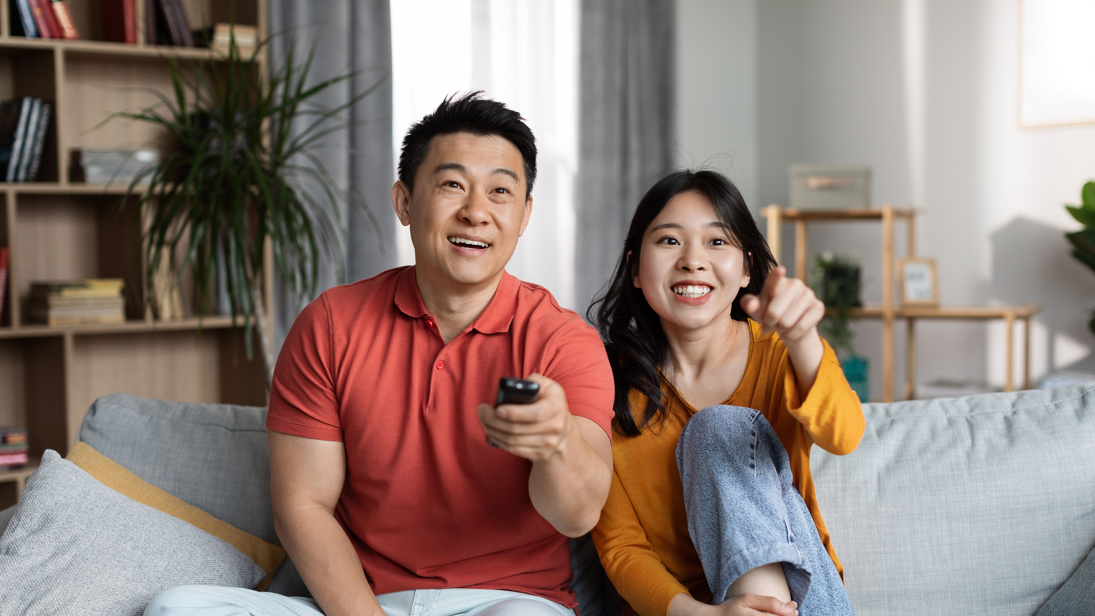 Happy man and woman watching TV at home