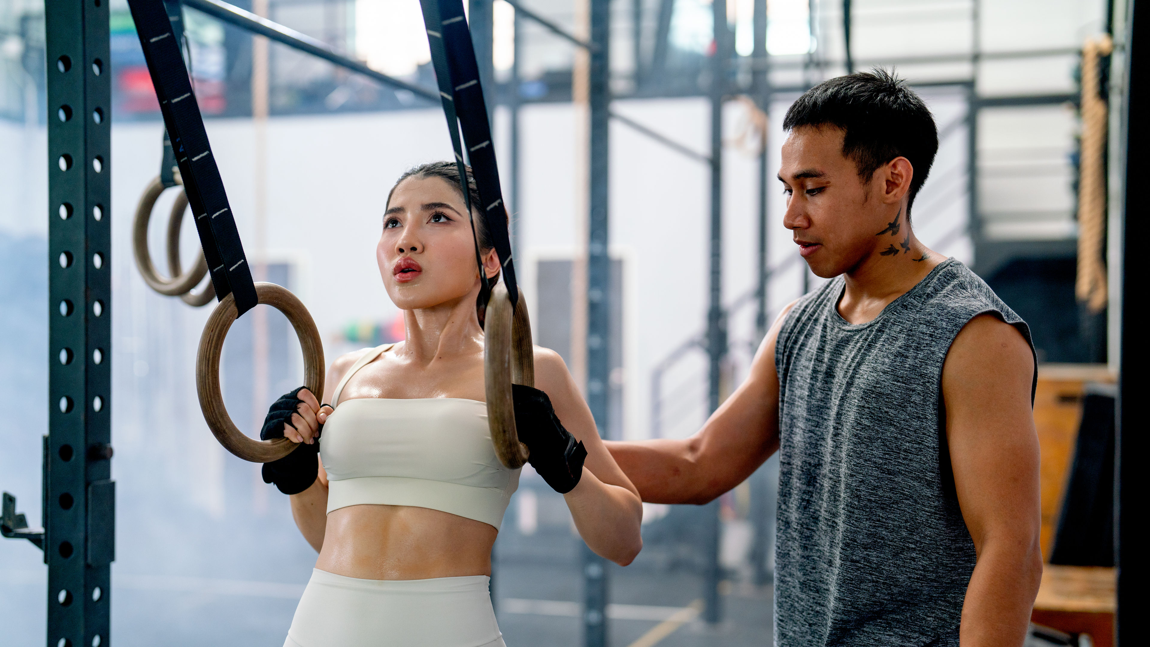Trainer helps and supports sporty women to exercise with loop