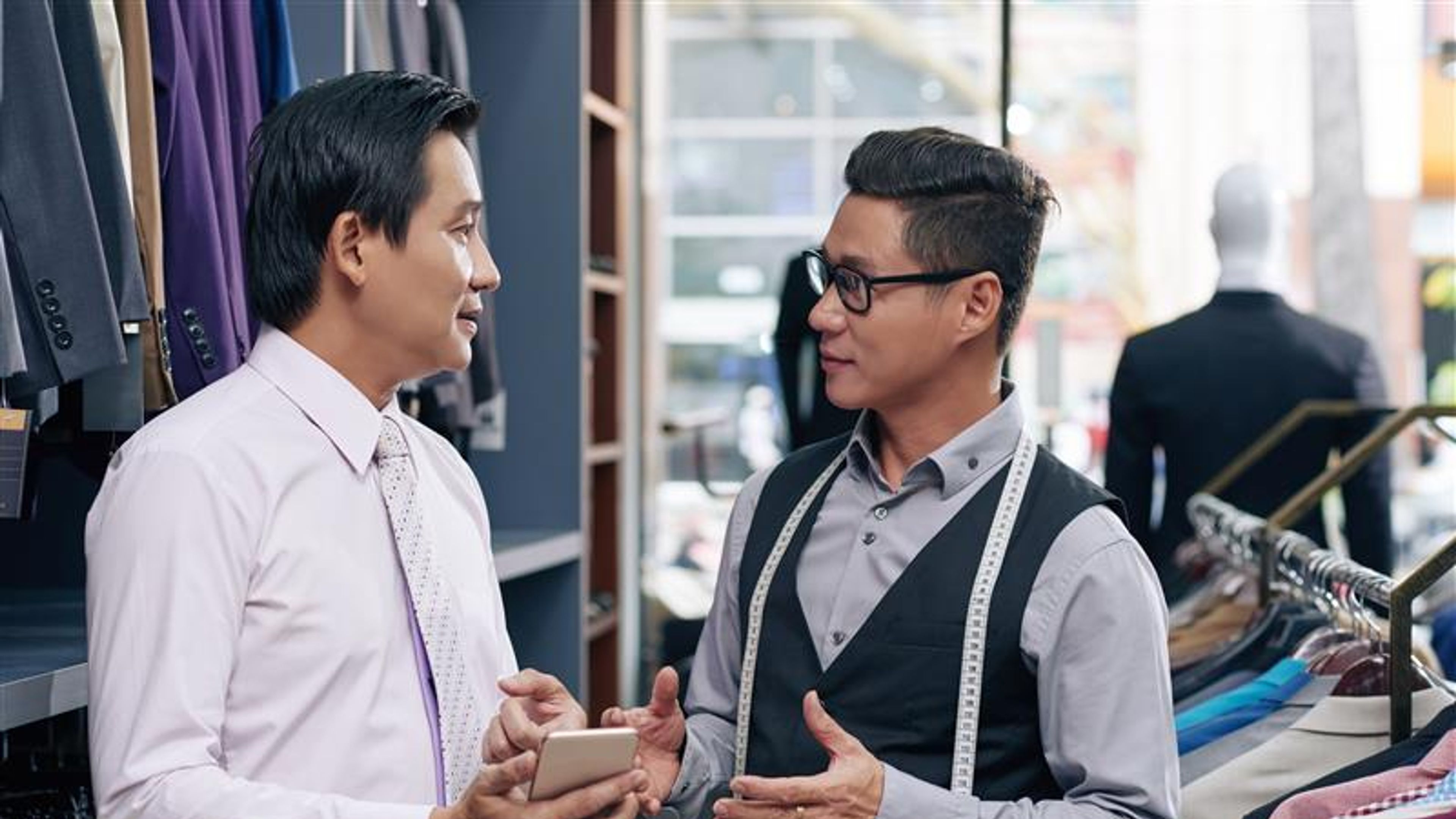 Dalawang lalaki ang nag-uusap sa isang fashion shop