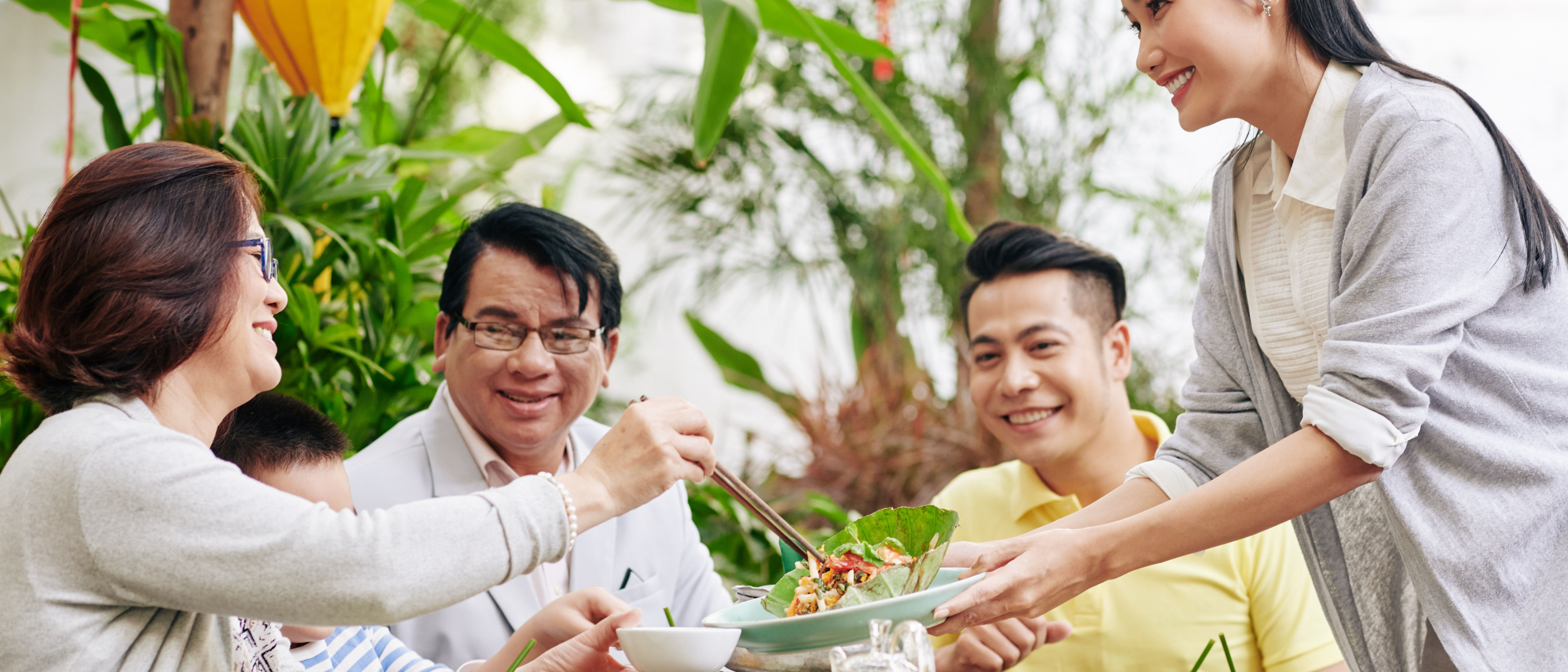 Woman offering salad to guests