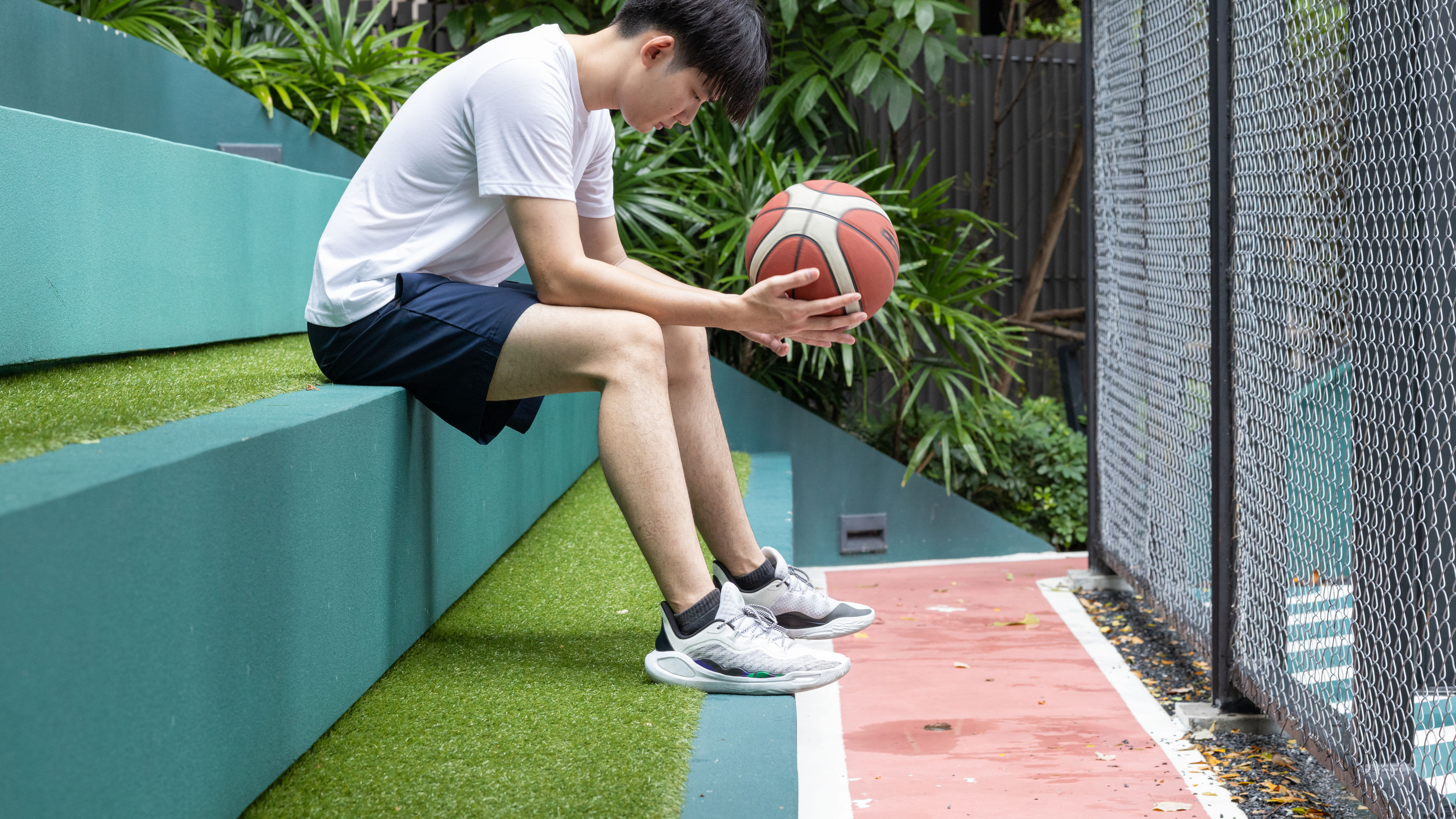 Young Man sitting with basketball on steps